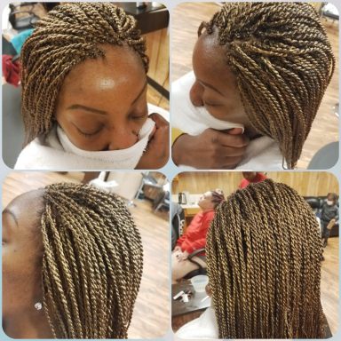 Close-up of a person with beautifully styled, braided hair in a salon setting.